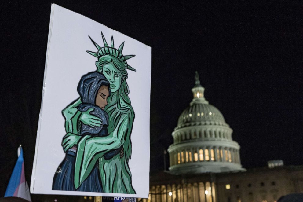 A sign depicts the Statue of Liberty embracing an immigrant during a protest against the termination of the Deferred Action for Childhood Arrivals program (DACA) at the Capitol on the eve of a government shutdown, Jan. 19, 2018, in Washington, D.C.