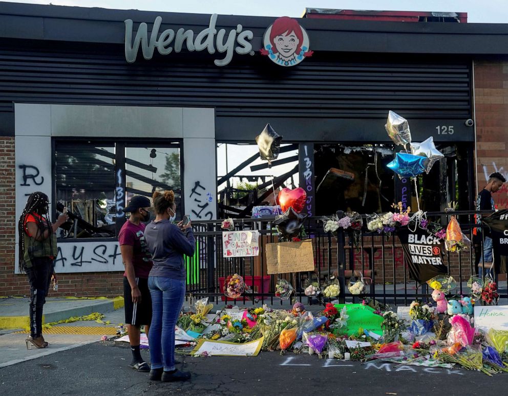 PHOTO: People take photos of a memorial to Rayshard Brooks at the Wendy's where he was shot and killed by police officers, in Atlanta, June 17, 2020.
