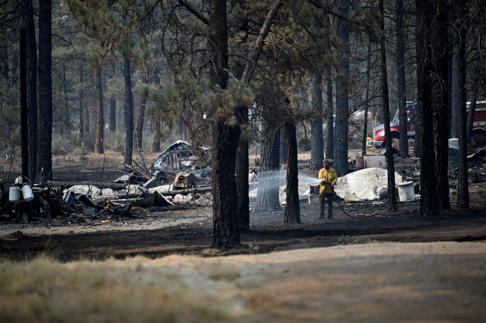 PHOTO: Volunteer firefighters spray water on hotspots from an isolated structure fire which was successfully extinguished the night before, as the Bootleg Fire expanded to over 200,000 acres, in Klamath Falls, Oregon, July 13, 2021.