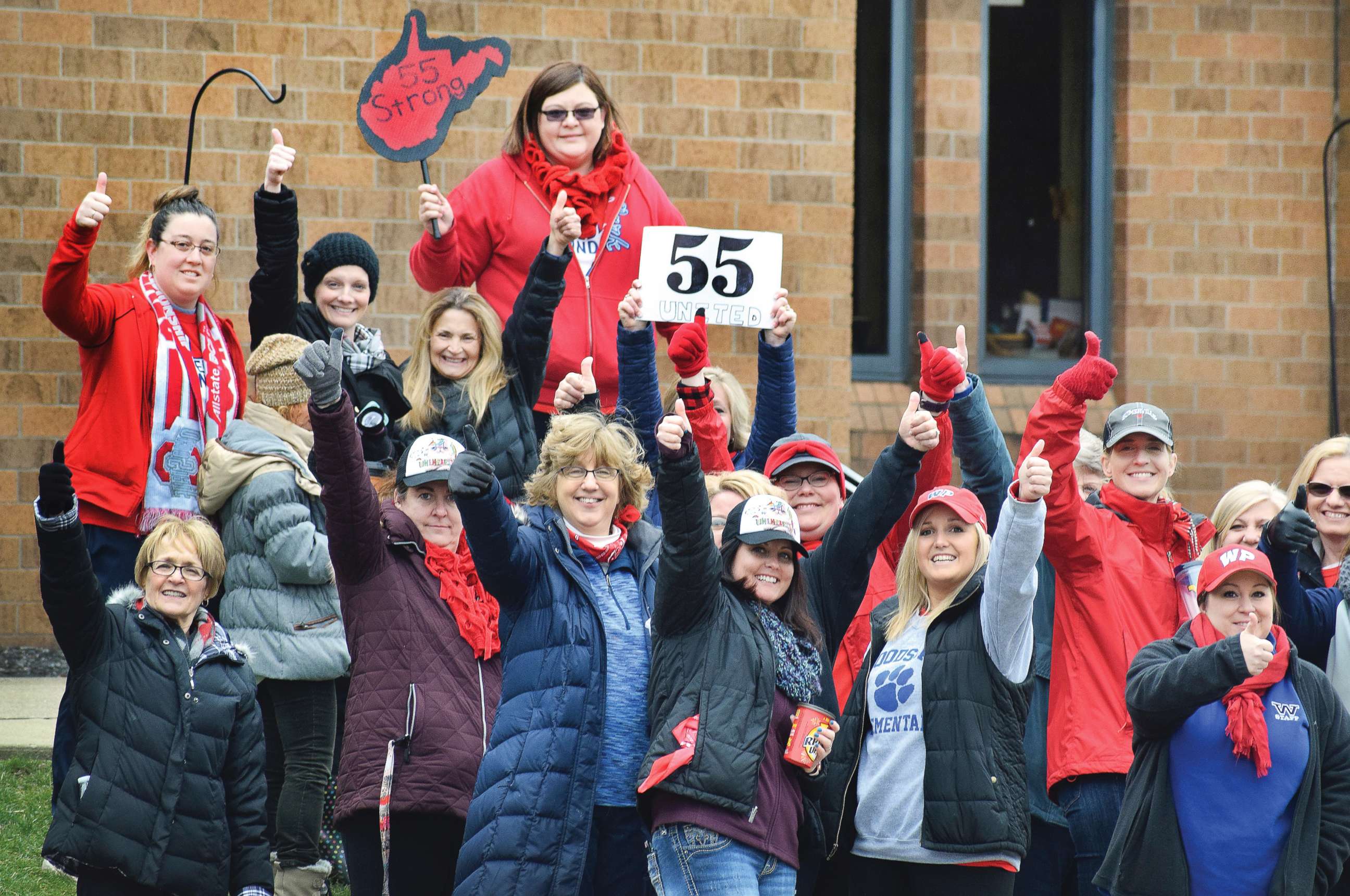 PHOTO: Teachers give a thumbs-up in front of Woodsdale Elementary in Wheeling, W. Va., on March 6, 2018, after teachers across the state received notice that a deal was reached to end the teacher walkout.