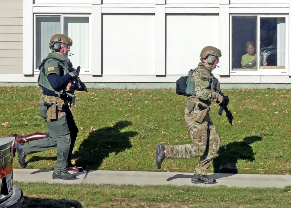 PHOTO: Police officers run past the Babcock Village apartments, Dec. 19, 2019, in Westerly, R.I. State Police said a shooting at the affordable housing complex for elderly and disabled left at least one person dead and two others injured.