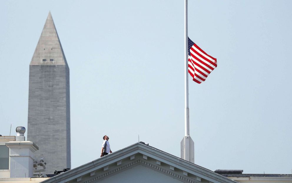 PHOTO: A worker looks up after lowering the flag over the White House in Washington to half-staff to honor victims of the shooting at the Capital Gazette Newspaper in Annapolis, Md., July 3, 2018.