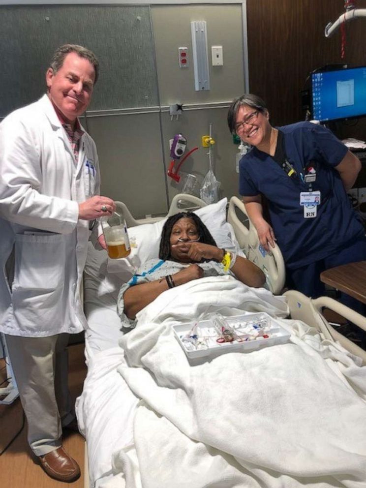 PHOTO: Dr. Martin Greenberg stands next to Whoopi Goldberg holding the fluid drained from her lungs during her battle with double pneumonia and sepsis.
