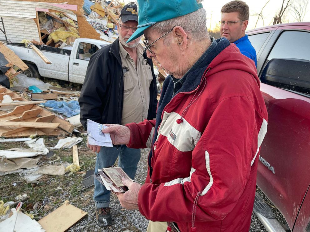 PHOTO: Wilbert Neil, 88, looks at photos salvaged from his destroyed home after a tornado struck in Gilbertsville, Ky., Dec. 12, 2021.