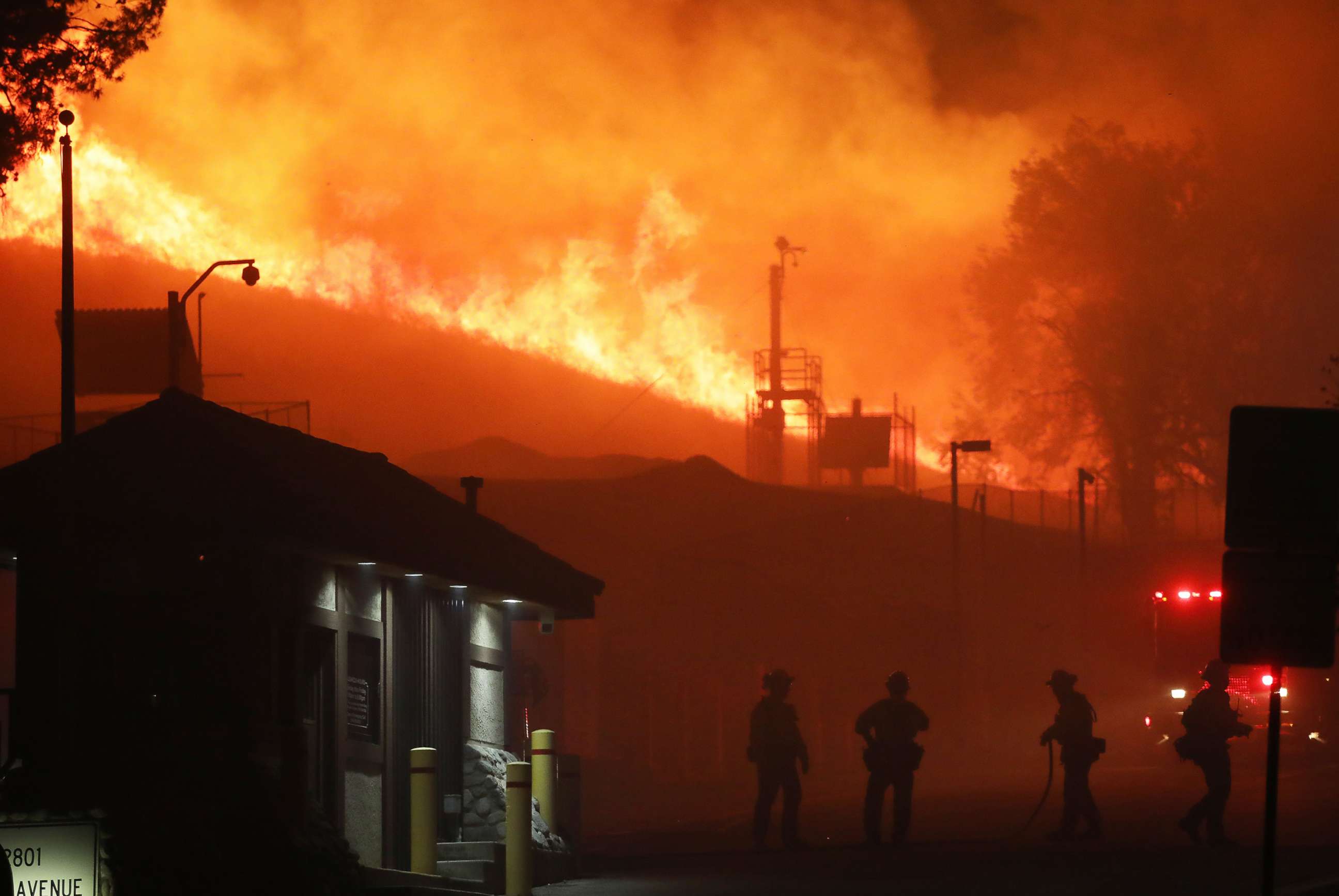 PHOTO: Firefighters work as the Saddleridge Fire burns in the early morning hours on Oct. 11, 2019, in Porter Ranch, Calif.