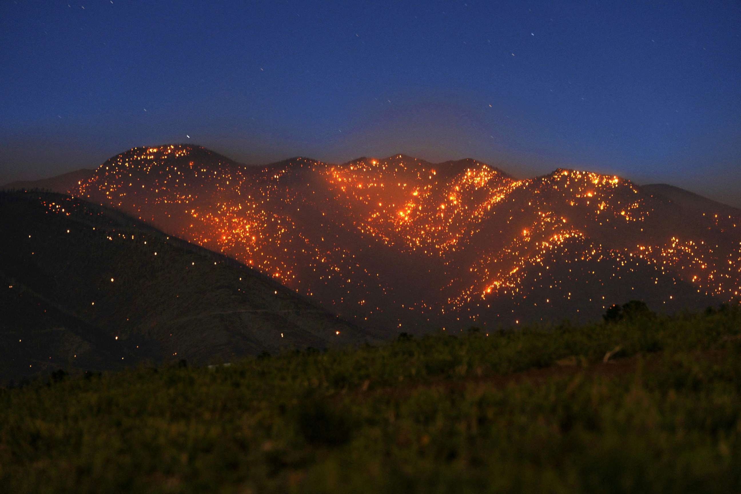 PHOTO: The Pipeline Fire leaves the mountains northeast of the San Francisco Peaks glowing with thousands of spot fires north of Flagstaff, Ariz., June 13, 2022. 