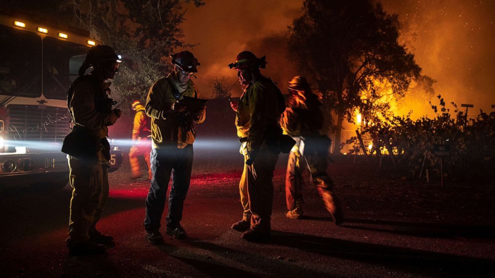 PHOTO: Firefighters plan their move as a building burns out of control, as the Kincade Fire continues to burn in Healdsburg, Calif., Oct. 27, 2019.