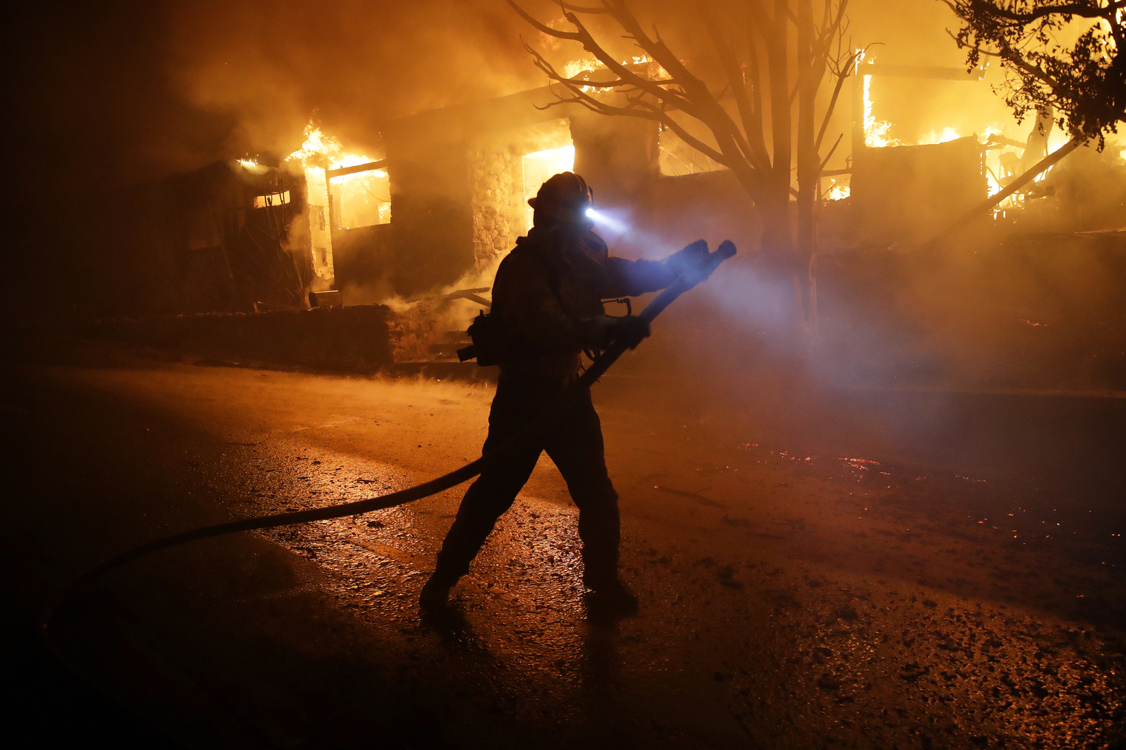 PHOTO: A firefighter gets in position to hose down flames as a home burns in the Getty fire area, Oct. 28, 2019, in Los Angeles. 