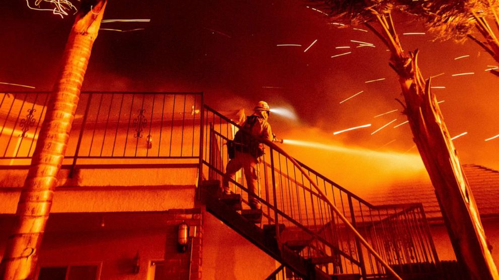 PHOTO: A firefighter sprays water as embers threaten a residence as the Hillside fire burns through San Bernardino, Calif., Oct. 31, 2019. 