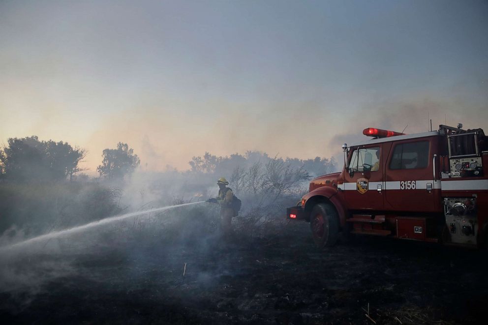 PHOTO: A firefighter hoses down hot spots while battling the Hillside fire, Oct. 31, 2019, in Riverside, Calif. 