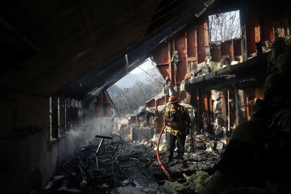 PHOTO: Capt. Adrian Murrieta with the Los Angeles County Fire Dept., looks for hot spots on a wildfire-ravaged home, Nov. 10, 2018, in Malibu, Calif. 