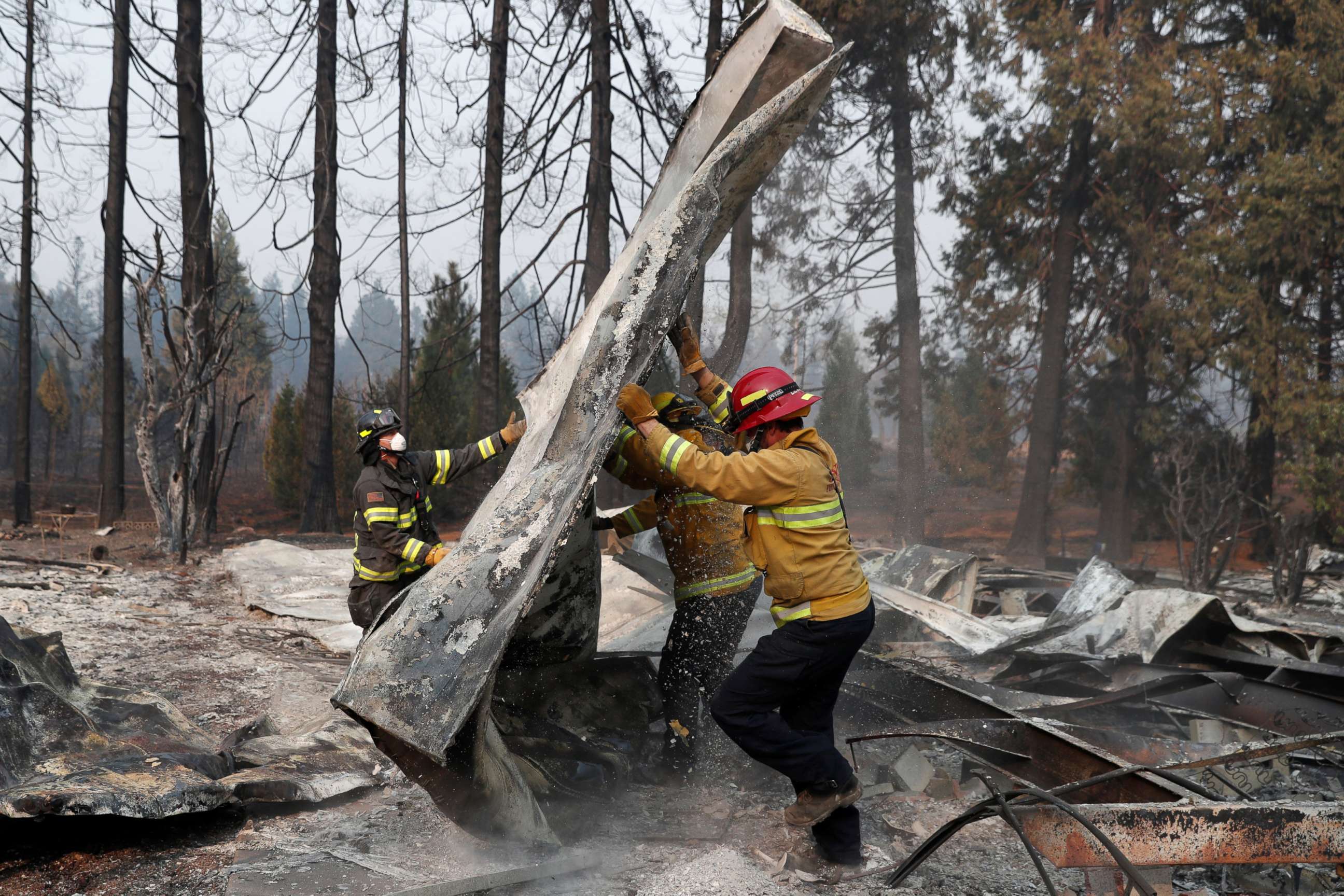 PHOTO: Firefighters move debris while recovering human remains from a trailer home destroyed by the Camp Fire in Paradise, Calif., Nov. 17, 2018. 