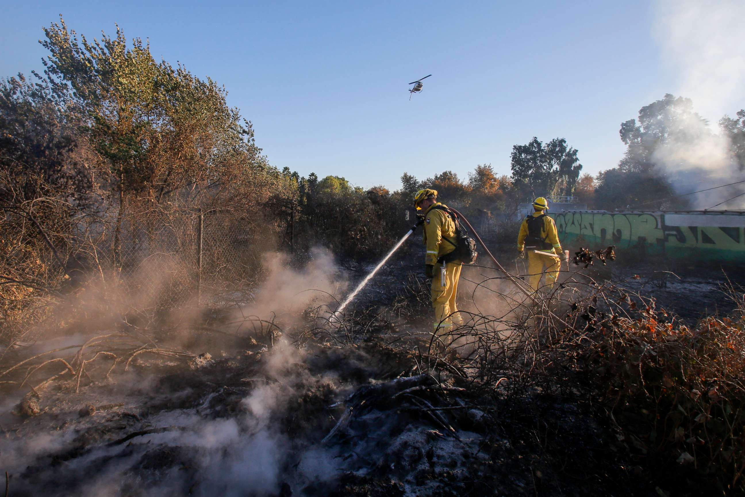 PHOTO: Firefighters put out hotspots in a wildfire in Riverside, Calif., Oct. 31, 2019. 