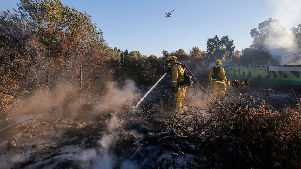 PHOTO: Firefighters put out hotspots in a wildfire in Riverside, Calif., Oct. 31, 2019. 