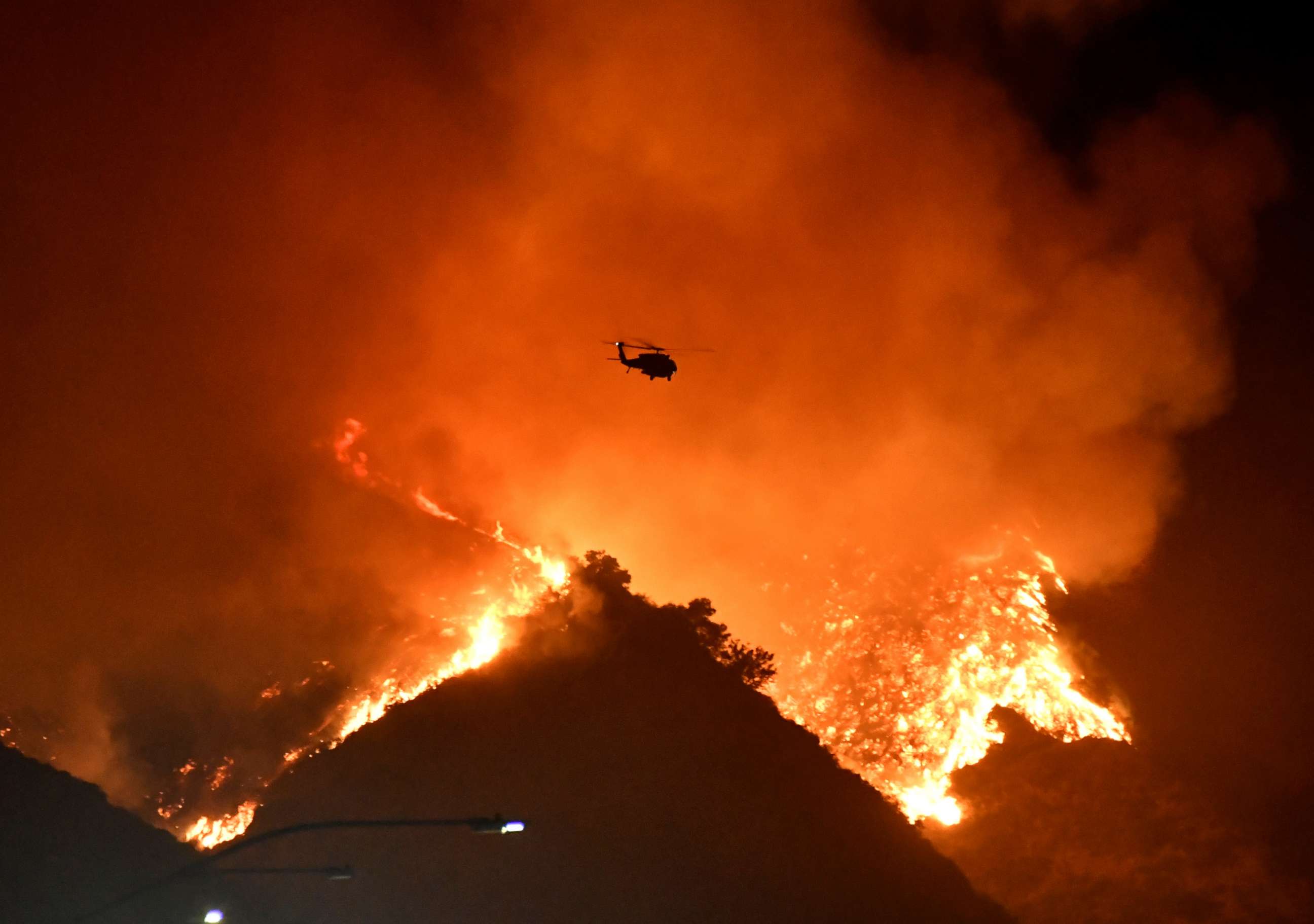 PHOTO: A firefighting helicopter flies over the Getty Fire as it burns in the hills west of the 405 freeway in the hills of West Los Angeles, Oct. 28, 2019.   