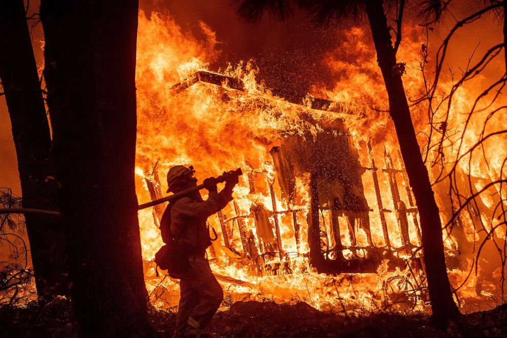 PHOTO: Firefighter Jose Corona sprays water as flames from the Camp Fire consume a home in Magalia, Calif., Nov. 9, 2018.