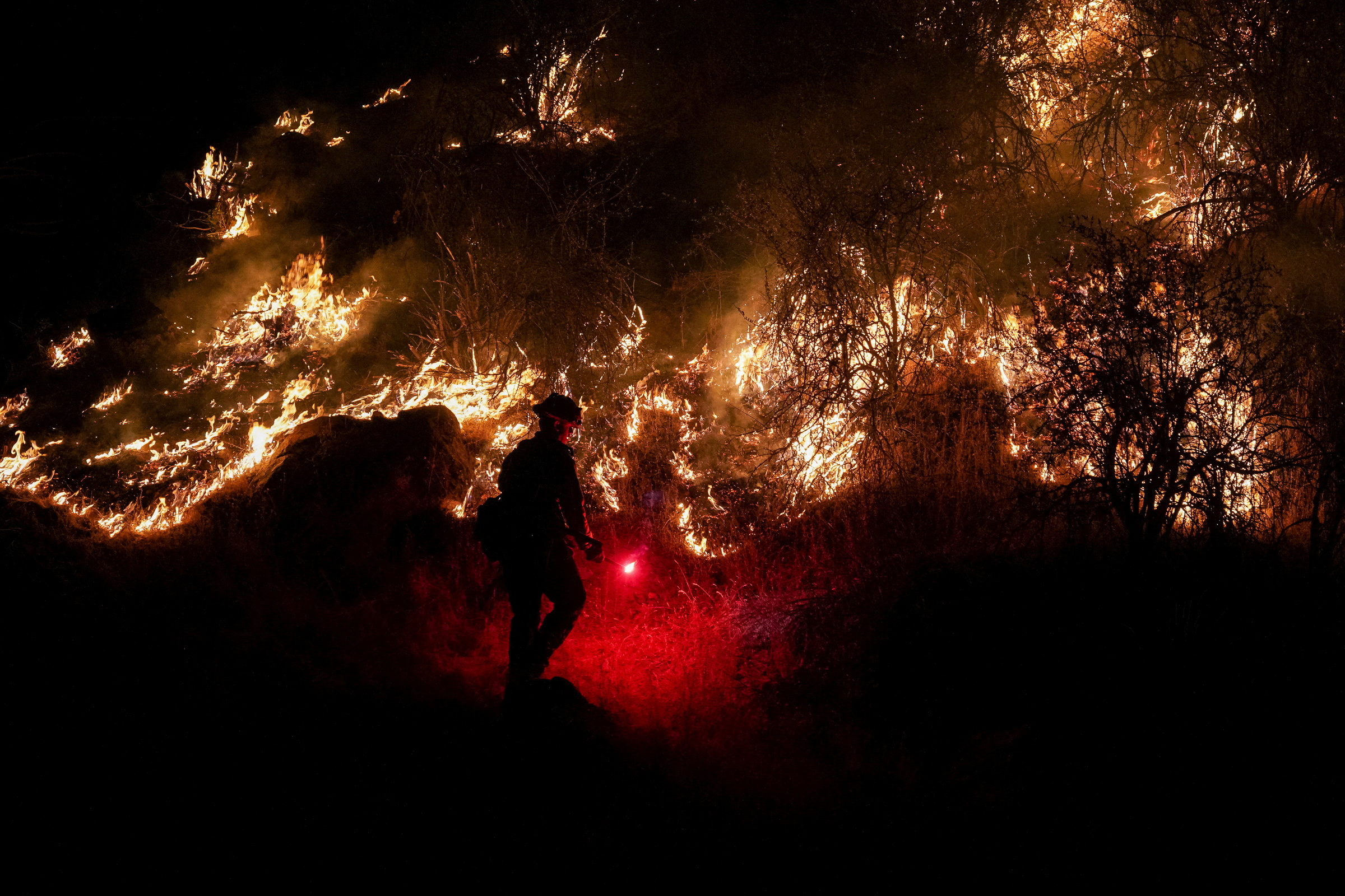 PHOTO: A firefighter works to mitigate the flames as the Oak Fire burns near Mariposa, Calif., July 22, 2022.
