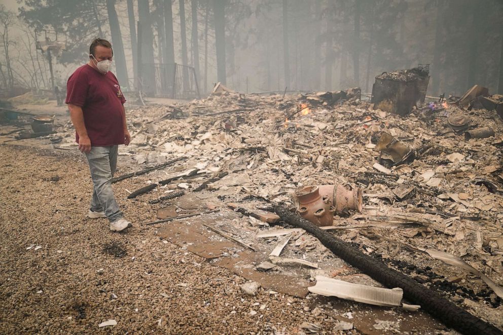 PHOTO: Peter Koleckar walks around a burned down home in his neighborhood after the CZU August Lightning Complex Fire passed through on Aug. 20, 2020, in Bonny Doon, Calif. The fire spared Koleckar's home.