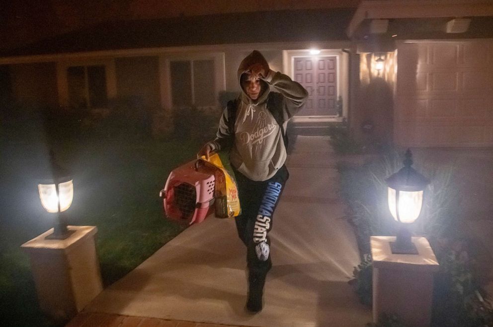 PHOTO: A woman evacuates her home with her cat as the Saddleridge fire threatens homes in Granada Hills, Calif., Oct. 11, 2019.