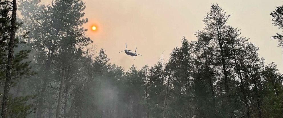 PHOTO: This image provided by the The Michigan Department of Natural Resources shows emergency personnel, aircraft and heavy equipment being used to suppress the wildfire near Grayling, Mich., June 3, 2023.
