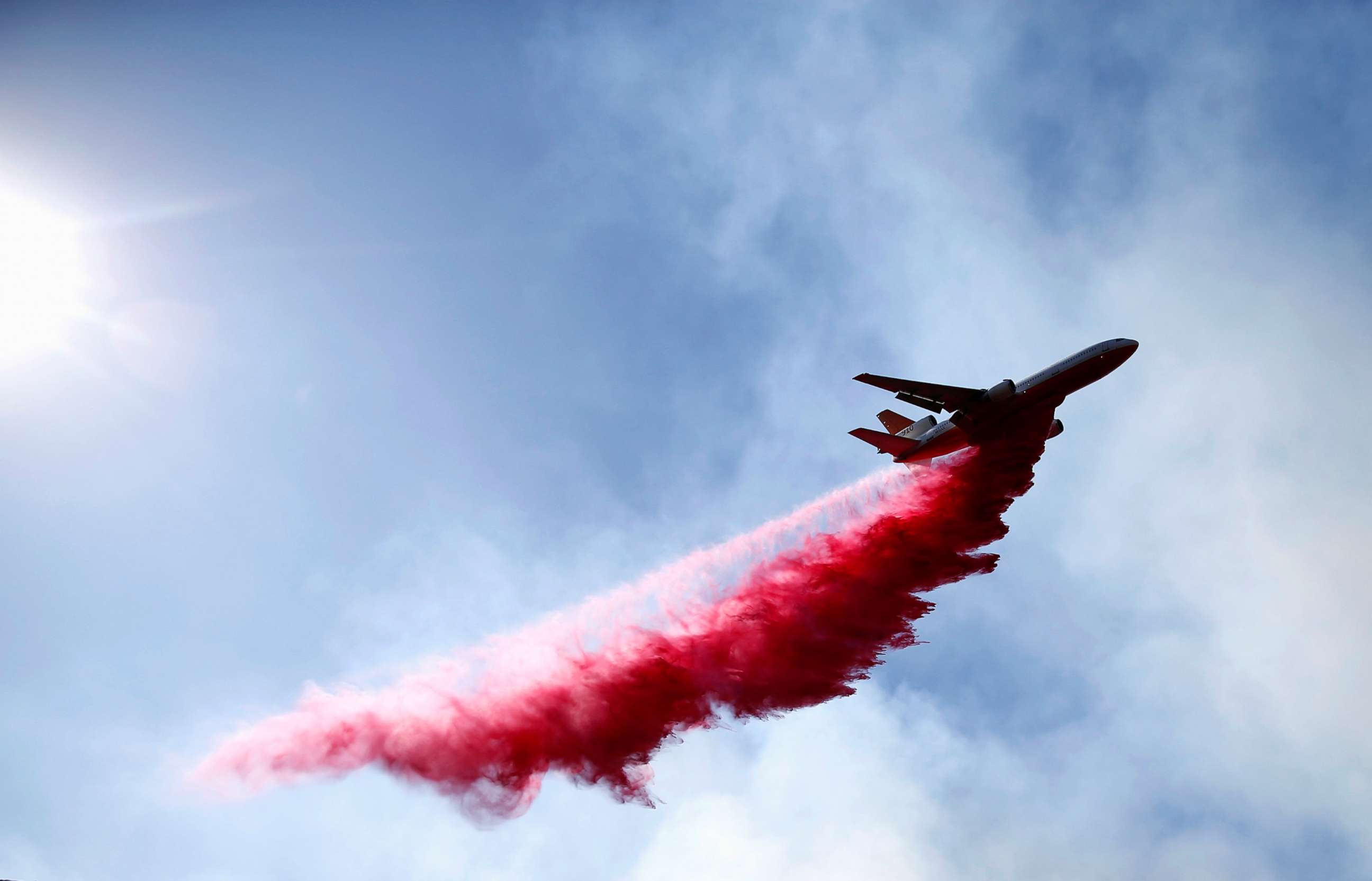 PHOTO: An aircraft drops flame retardant as firefighters battle the Woolsey Fire as it continues to burn in Malibu, Calif., Nov. 11, 2018. 