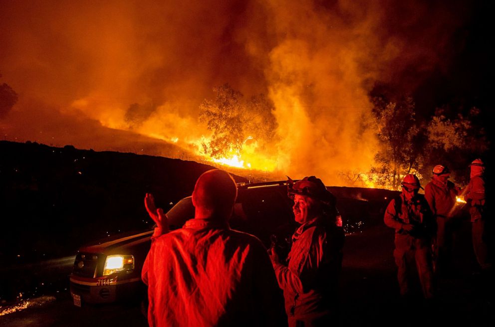 PHOTO: Firefighters confer while battling the Kincade Fire near Geyserville, Calif., Oct. 24, 2019.