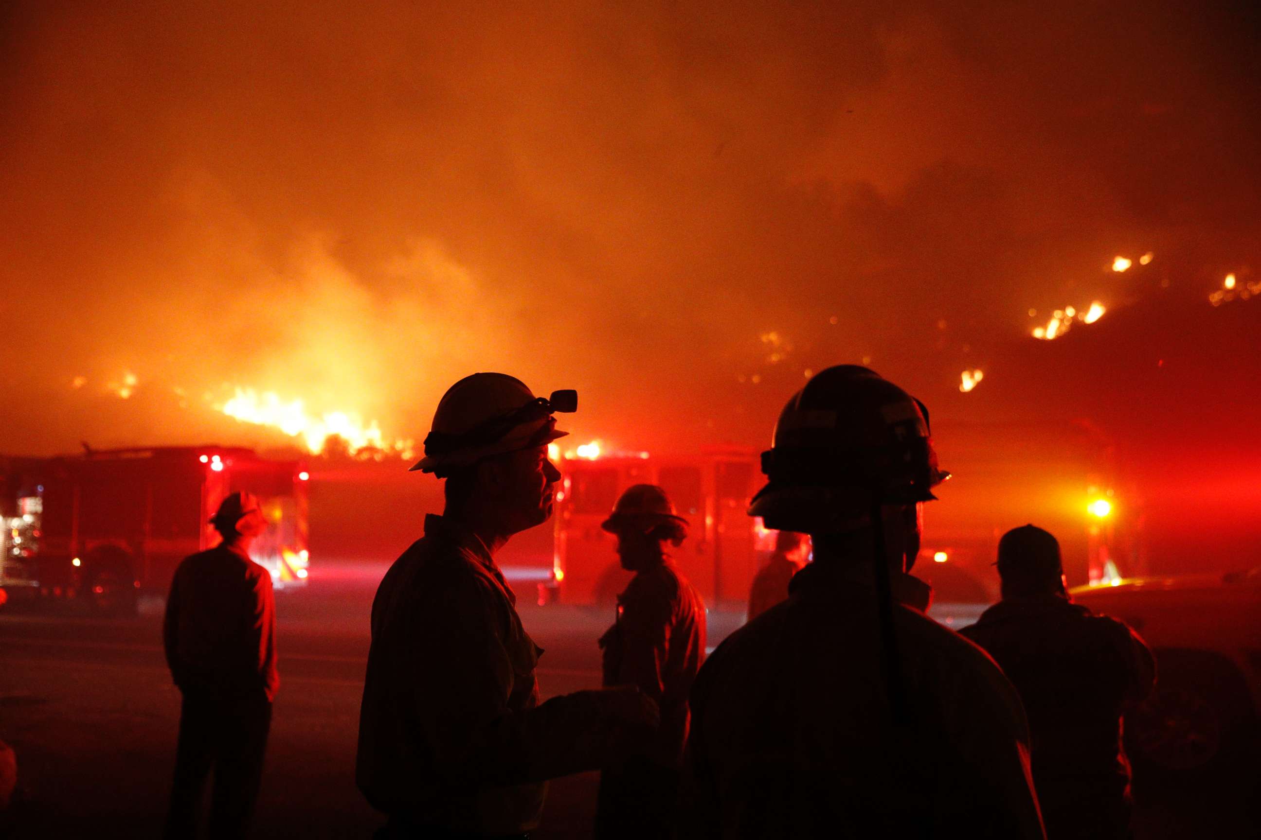 PHOTO: Firefighters gather in front of a residential area as a wildfire burns along the 101 Freeway, Dec. 5, 2017, in Ventura, Calif. 