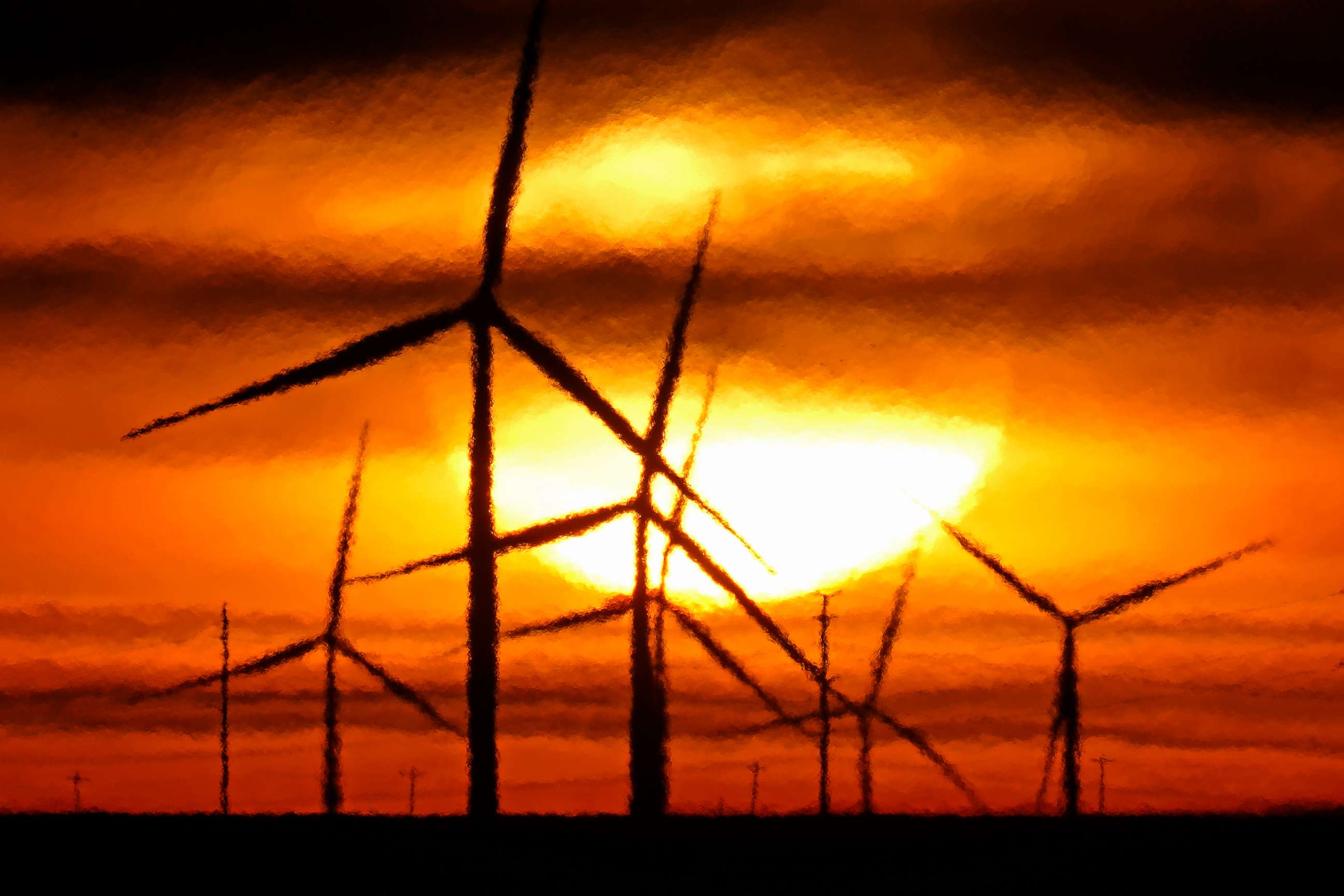 PHOTO: Wind turbines are silhouetted against the rising sun, Jan. 13, 2021, near Spearville, Kan.