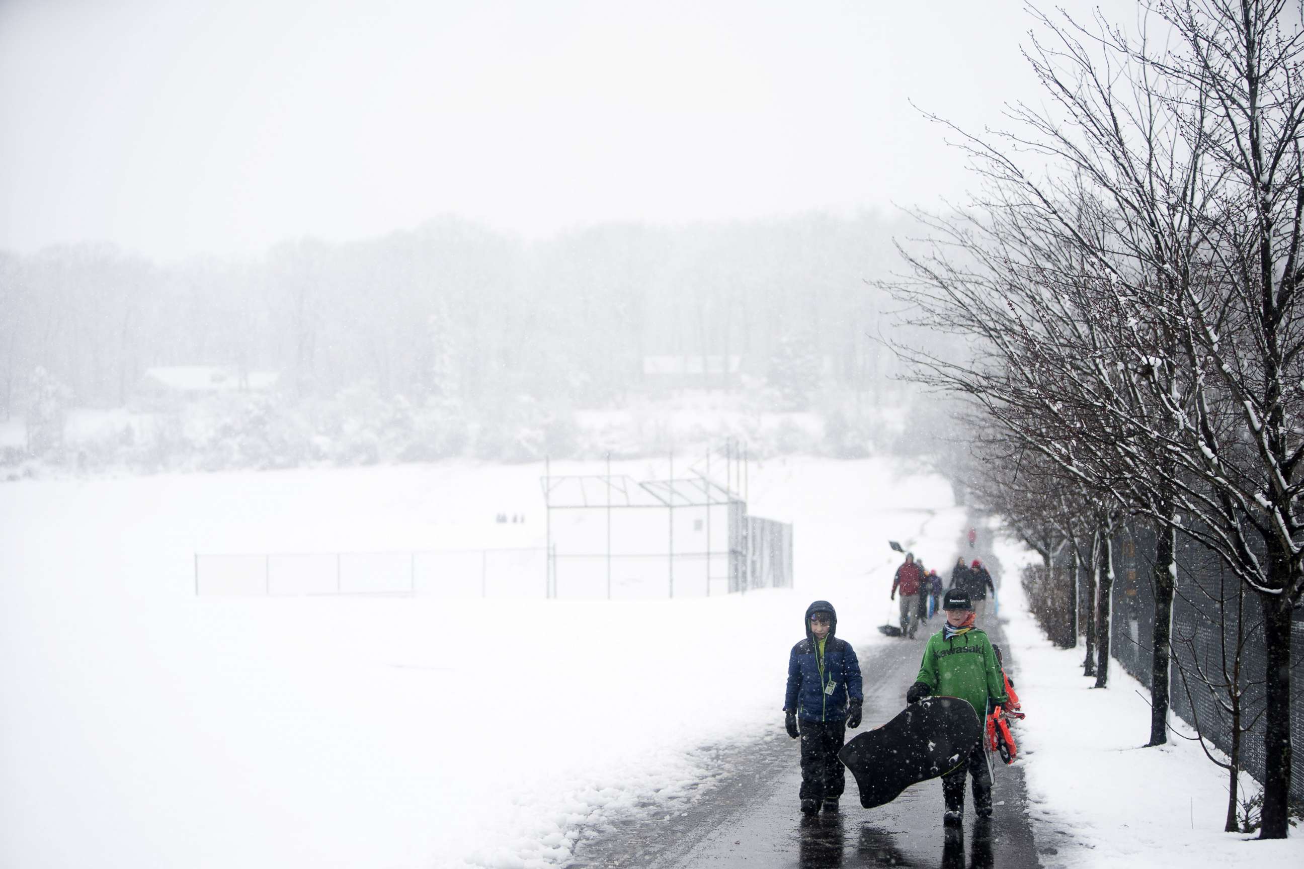 PHOTO: People drag and carry sleds through winter weather on March 7, 2018 in Perkasie, Pennsylvania.