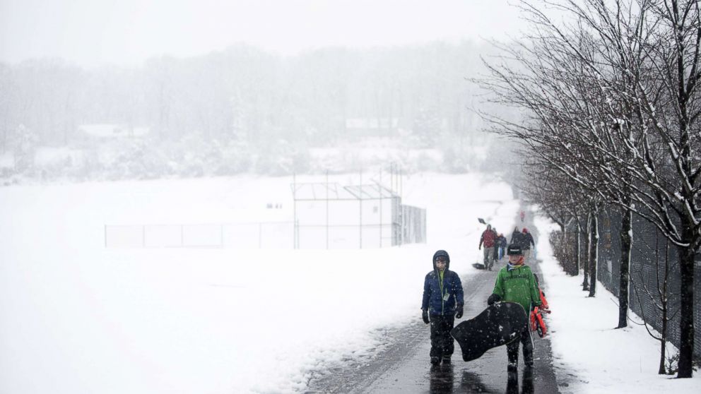 PHOTO: People drag and carry sleds through winter weather on March 7, 2018 in Perkasie, Pennsylvania.