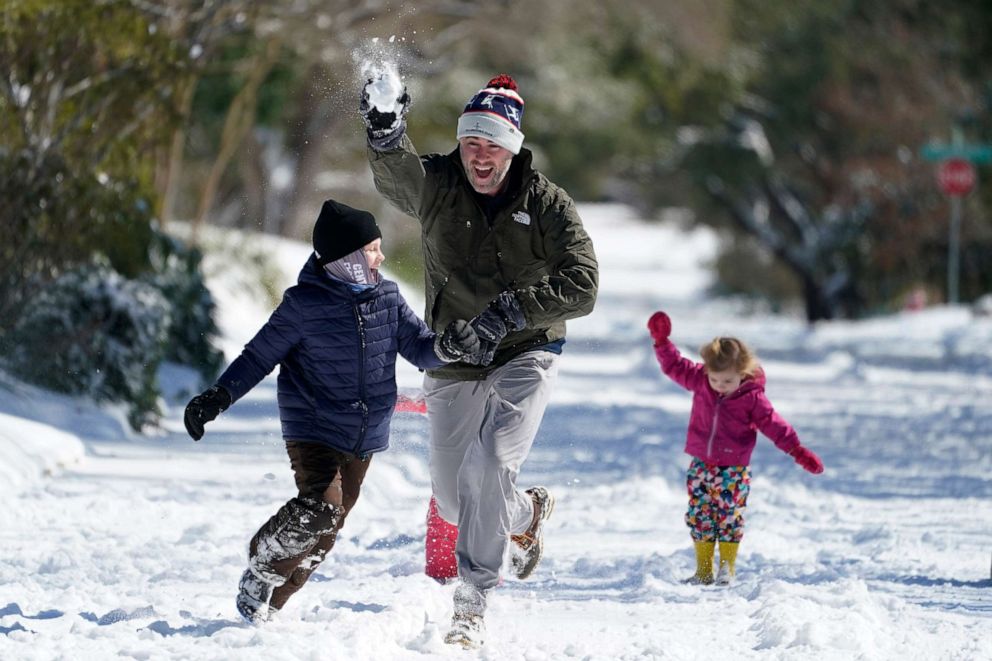PHOTO: Craig Crow, center, plays in the snow with his children and neighbors, Feb. 15, 2021, in San Antonio.