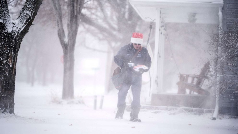 PHOTO: Mail carrier Dennis Niles braves the blowing snow as blizzard like conditions hit Osseo and the Twins Cites on Dec. 23, 2020 in Osseo, Minn.