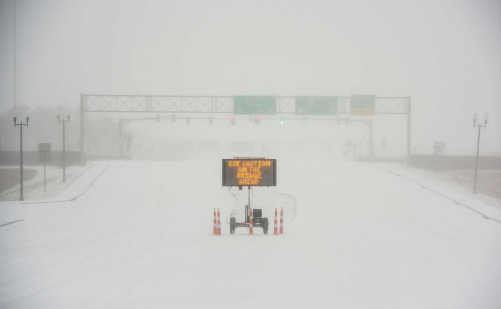 PHOTO: A sudden heavy bout of snow and frozen rain makes visibility low on a highway in Madison, Miss., early on Feb. 15, 2021.