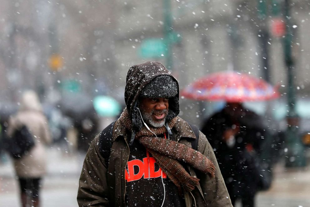 PHOTO: People make their way through falling snow in lower Manhattan in New York, Dec. 2, 2019.