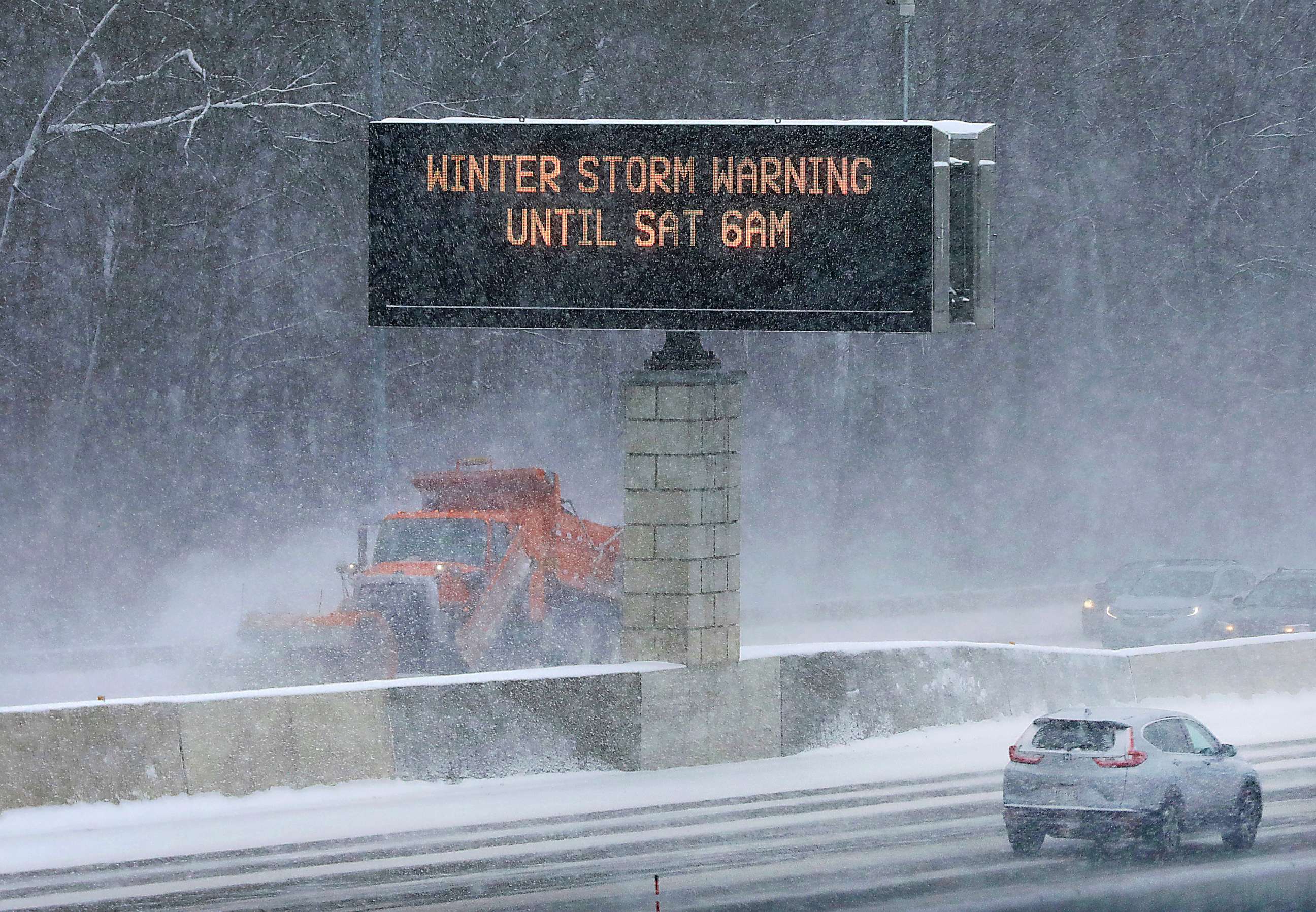 PHOTO: Traffic and snow maintenance vehicles clear the roadway as a traffic sign cautions drivers about the conditions along State Highway 14/18, Dec, 22, 2022, in Madison, Wis.