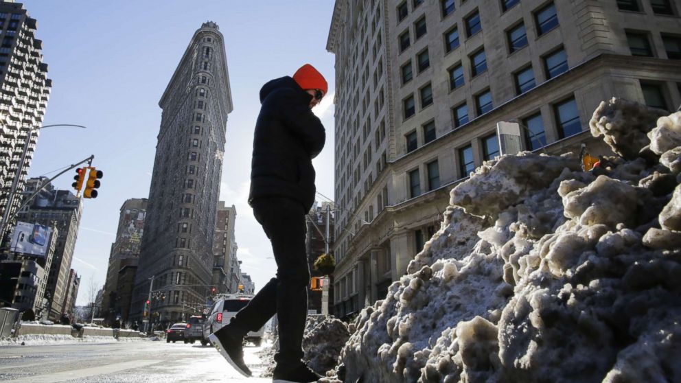 PHOTO: A man walks pass snow accumulated on the sidewalk as the Flatiron Building is pictured during freezing temperatures. Jan. 7, 2018, in New York City.
