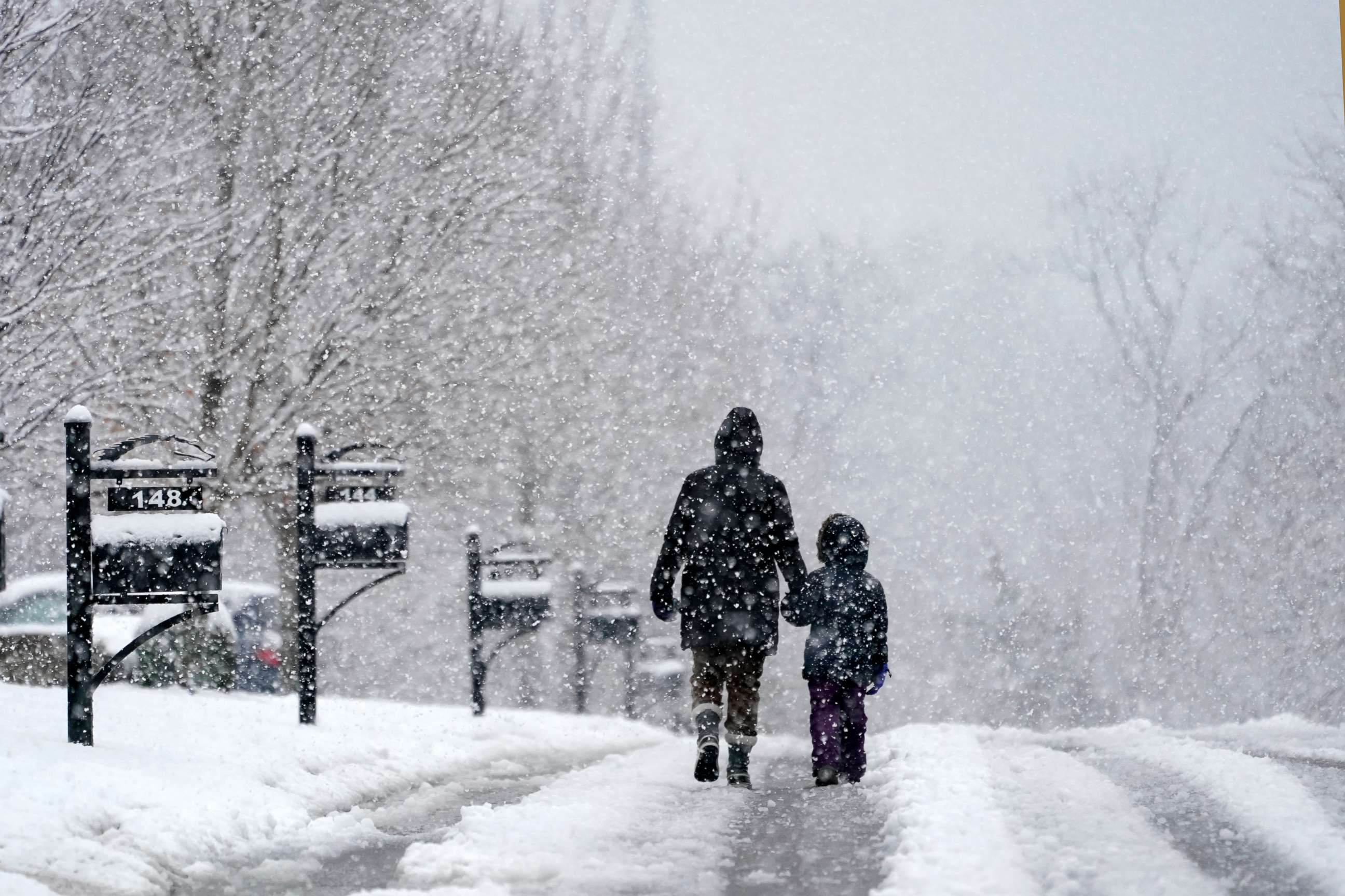 PHOTO: People go for a walk as snow falls, Jan. 16, 2022, in Nolensville, Tenn.