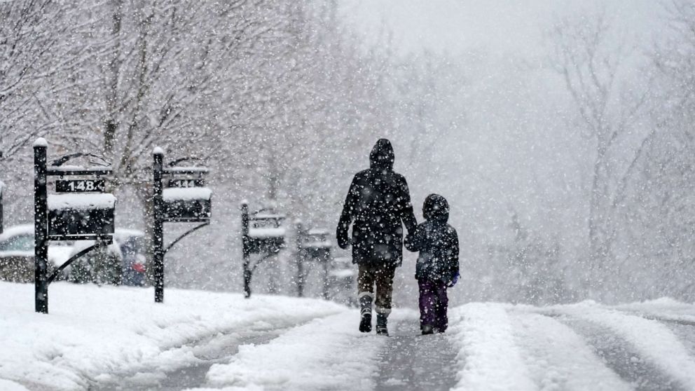 PHOTO: People go for a walk as snow falls, Jan. 16, 2022, in Nolensville, Tenn.