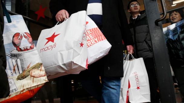 FILE - Shoppers leave Macy's in Boston, Nov. 29, 2019. (AP Photo/Michael Dwyer, file)