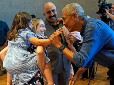 Barack and Michelle Obama surprise first visitors to newly opened presidential center