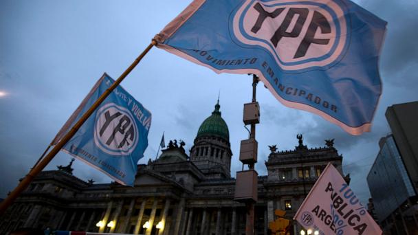 FILE - Supporters of an oil nationalization bill proposed by Argentina's President Cristina Fernandez wave flags that read in Spanish: "Fight and return YPF," outside Congress in Buenos Aires, Argentina, April 25, 2012. (AP Photo/Natacha Pisarenko, File)