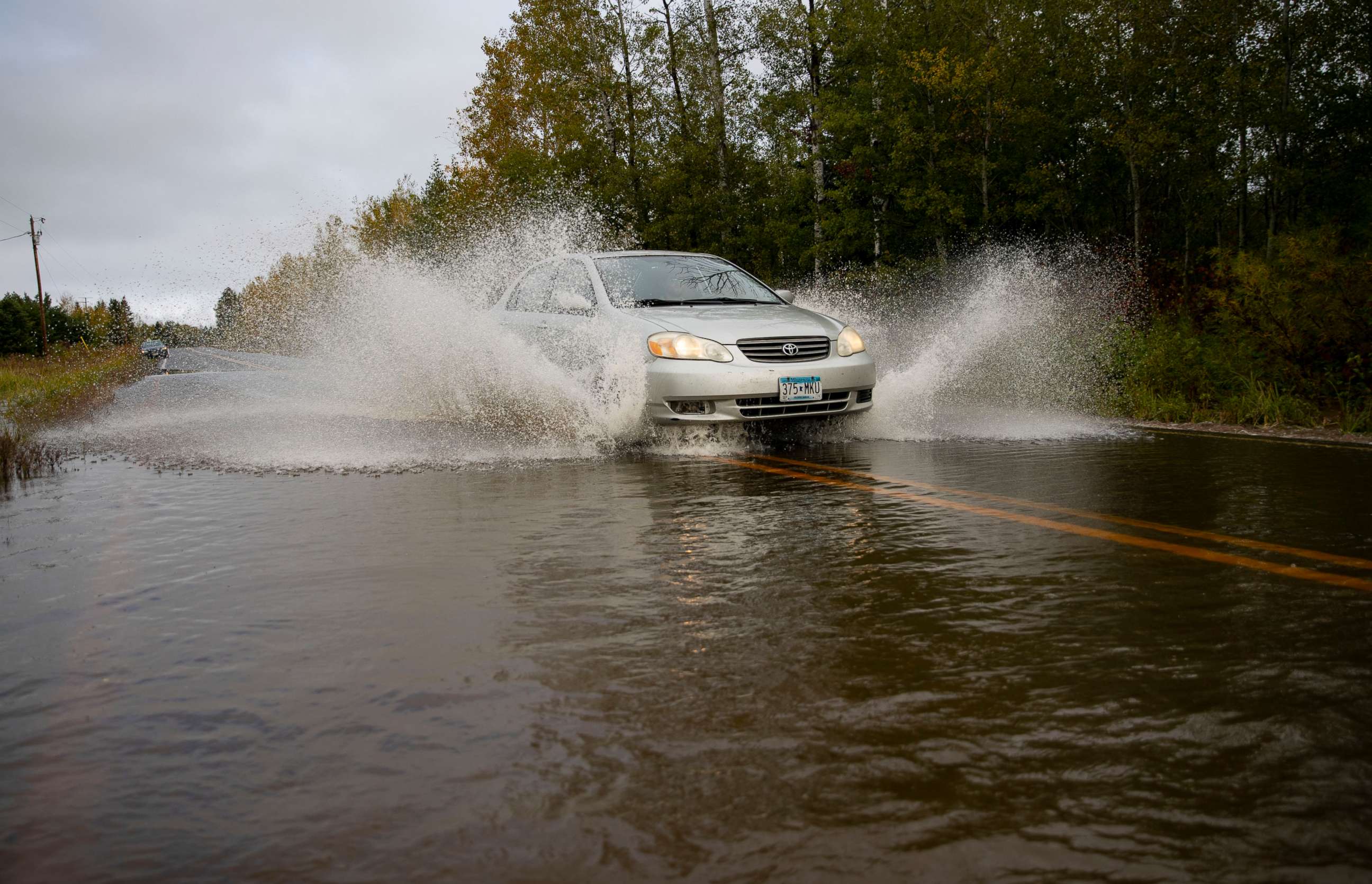 PHOTO: A car passes through high water in a section of County Highway K in South Range, Wis, Monday, Sept. 30, 2019. The road was washed out and eventually closed off on Monday morning due to heavy rain that started Sunday night.