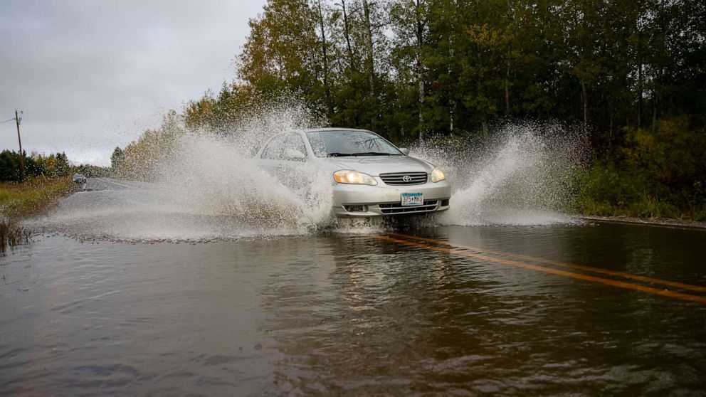 PHOTO: A car passes through high water in a section of County Highway K in South Range, Wis, Monday, Sept. 30, 2019. The road was washed out and eventually closed off on Monday morning due to heavy rain that started Sunday night.