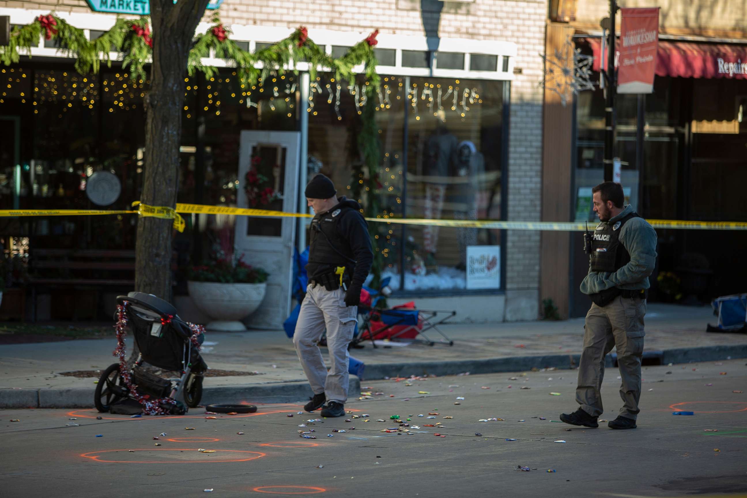 PHOTO: In this Nov. 22, 2021, file photo, police canvas debris left after a driver plowed into the Christmas parade on Main Street in downtown Waukesha, Wis.