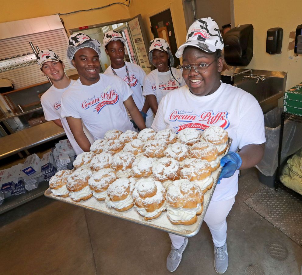 PHOTO: Jahtaiya Woolley, a team cream puff crew member, proudly holds a tray of fresh cream puffs with her fellow team cream puff crew members at the State Fair Park in West Allis, Wisc., July 31, 2019, prior to the start of the Wisconsin State Fair.