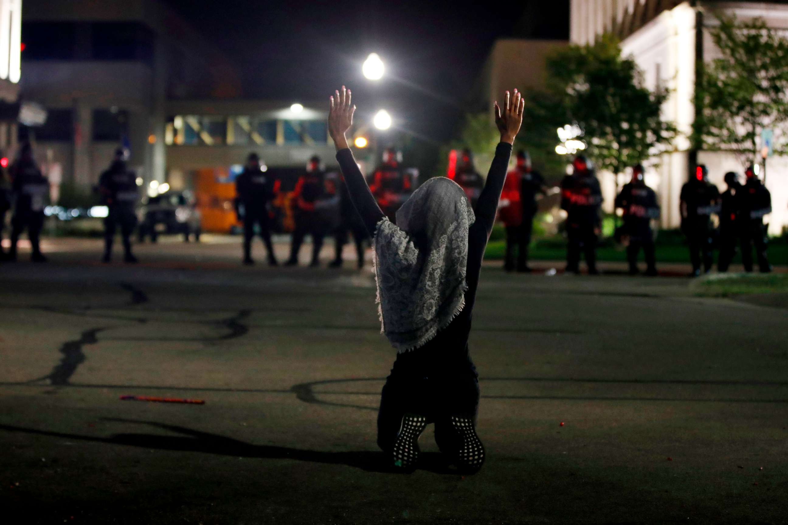 PHOTO: A protester holds her hands up as she kneels in front of Kenosha County Sheriff's officers by the County Court House during demonstrations against the shooting of Jacob Blake in Kenosha, Wisc., on Aug. 24, 2020.