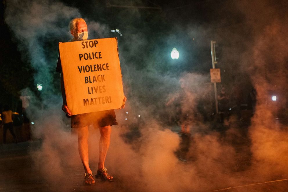 PHOTO: A man stands with a sign on Aug. 24, 2020 in Kenosha, Wisc.