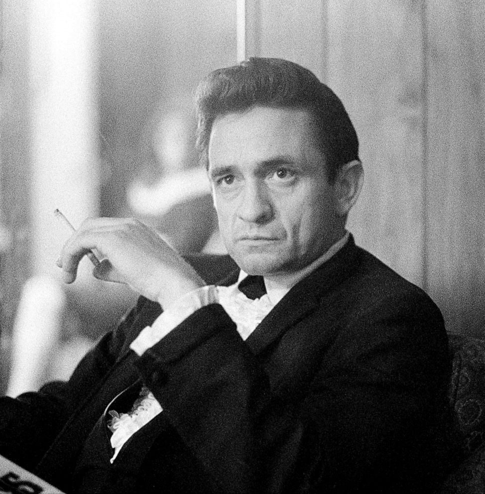 PHOTO: Johnny Cash smokes a cigarette backstage at the Circle Star Theatre in San Carlos, Calif., December 1967. His wife, June Carter Cash, is in the background.