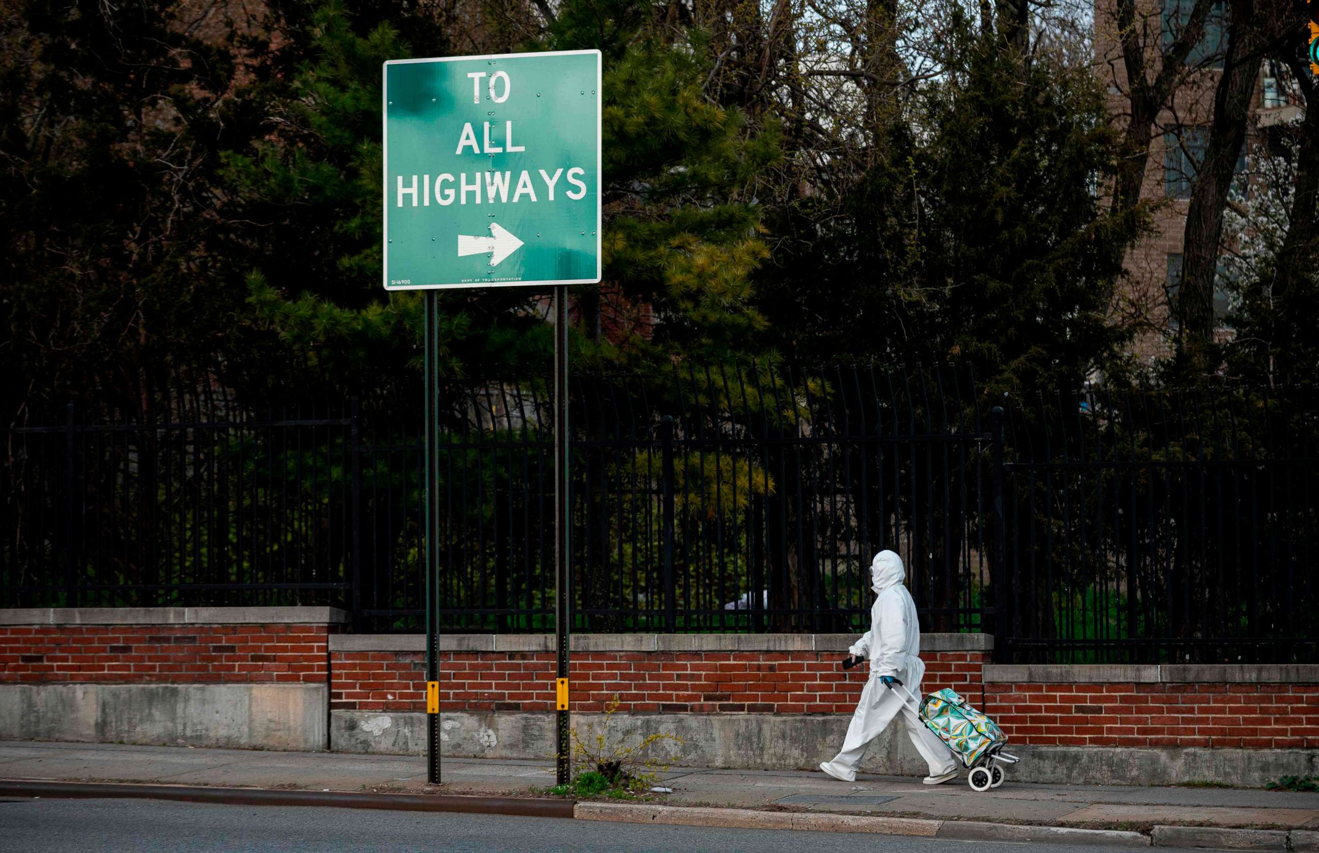 PHOTO: A woman wearing a hazmat suit and googles pulls her grocery cart in the streets of Queens, a borough of New York City, amid the coronavirus pandemic on April 20, 2020.