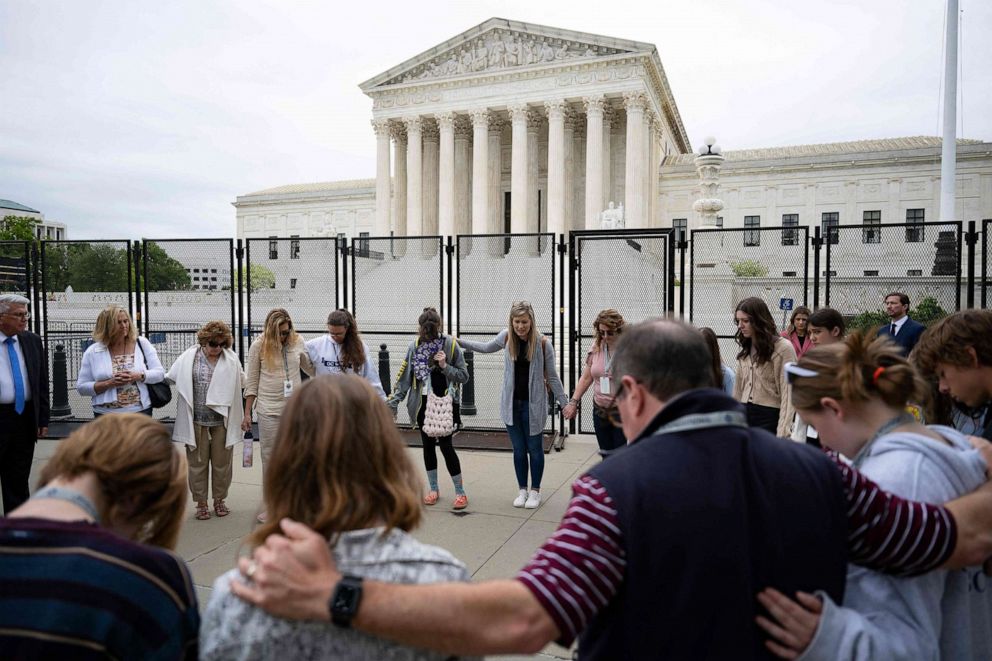 PHOTO: Anti-abortion demonstrators pray during a National Day of Prayer near an un-scalable fence that stands around the Supreme Court in Washington, D.C. May 5, 2022.